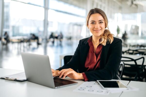 Młoda kobieta w biurze oferuje kompleksową pomoc w zakładaniu firmy.